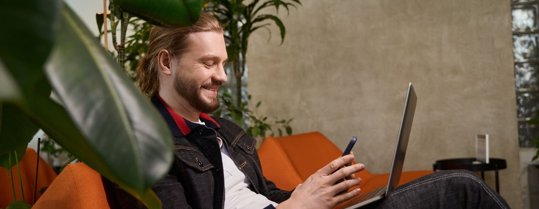 The essence of exceptional living a man sitting down with a phone and a computer
