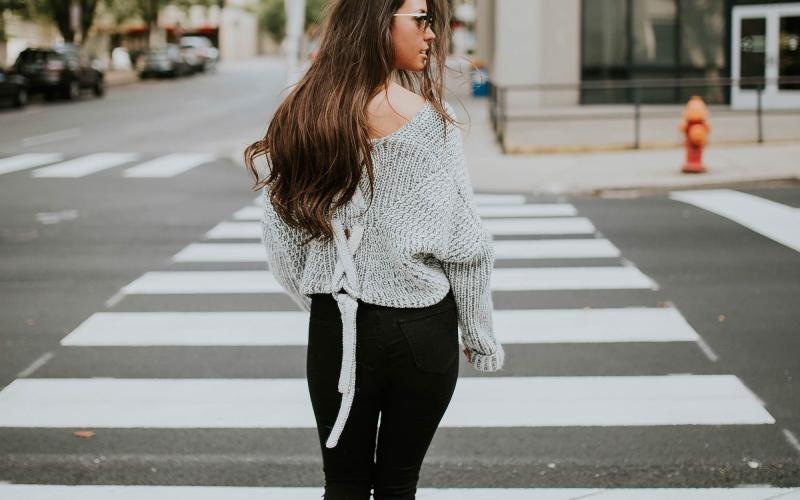 Close to the center of everything a person walking in a crosswalk