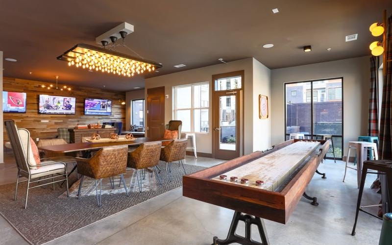 a room with games, tv's, tables and chairs